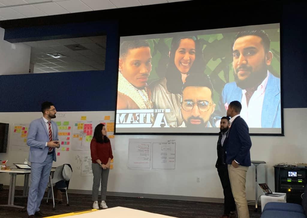 Trinity alumni Tim Flynn ’19 (front left) and Francesca L. Velarde ’19 (second from right) give a presentation during their Infosys training at Trinity’s Liberal Arts Action Lab on Constitution Plaza.